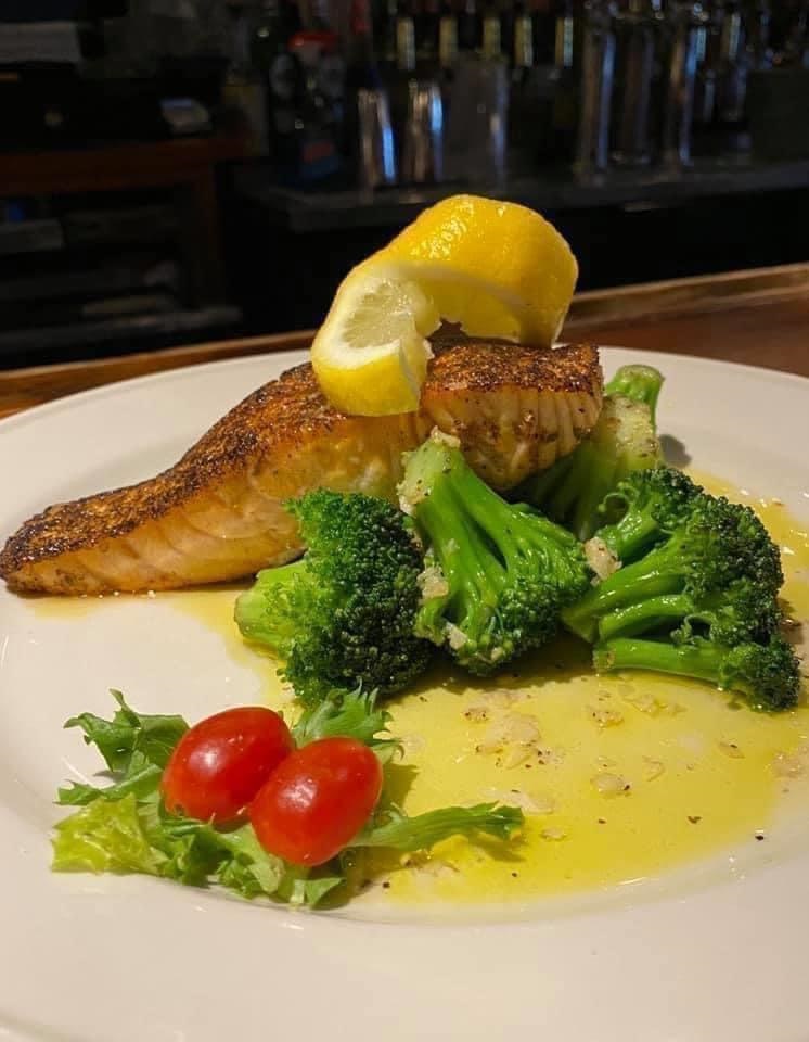 Blackened salmon fillet with a golden Cajun crust, plated with seasonal vegetables