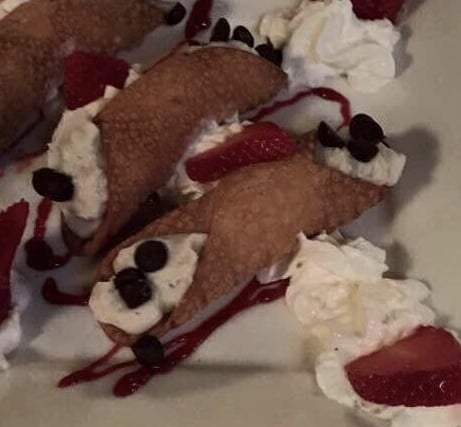 Crispy cannoli shell filled with sweet ricotta cream and chocolate chips