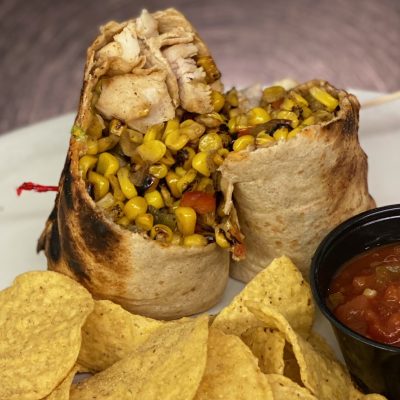 Southwestern chicken wrap sliced in half, showing colorful filling of chicken, peppers, and cheese